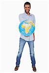 Happy man holding out a globe on white background