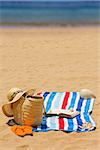 towel and sunbathing accessories on  beach by sea