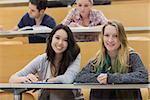 Girls smiling in lecture hall with tablet pc  in college