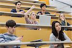 Students taking an active part in a lesson while sitting in a lecture hall