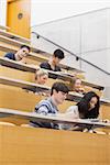 Students sitting in a lecture hall while learning and taking notes
