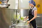 Woman washing the dishes in the restaurant kitchen