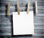 White paper hung on laundry line with wooden board on the background