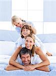 Family piled on top of dad in the bedroom