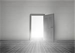 Door opening to reveal bright light in a dull grey room