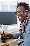 Cheerful graphic designer using a graphics tablet in a modern office