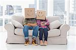 Silly workers wearing boxes on their heads with smiley faces on a couch