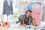 Thoughtful fashion designer sitting behind his desk