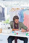 Fashion designer drawing clothes in a creative office