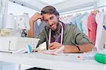 Happy designer working at his desk in a bright creative office