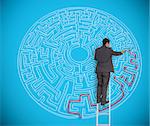 Businessman on ladder drawing red line to solve a complex maze on blue wall
