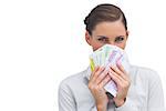 Businesswoman hiding behind money in her hand on white background