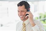 Laughing businessman on the phone in office