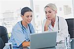 Two women doctors working on a laptop in the office