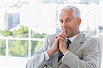 Happy businessman thinking in his office