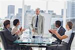 Colleagues applauding the boss during a meeting in the meeting room