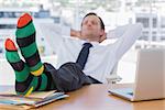 Businessman sleeping with feet without shoes on his desk