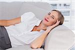 Smiling businesswoman lying on couch in bright office