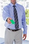 Businessman giving green business card in his office