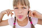 Little girl clogging her ears and wincing on white background