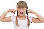 Funny little girl clogging her ears and wincing on white background