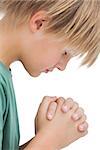 Little boy saying his prayers side view on white background