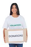 Smiling volunteer holding a donation box on white background