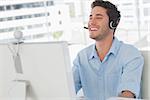 Happy designer laughing during an online communication in his office