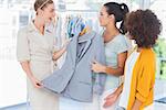 Smiling women holding a blazer in a creative office