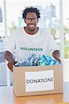 Happy man holding donation box with clothes