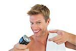 Cheerful man about to shave his stubble with an electric razor on white background