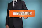 Businessman selecting the word innovation written on orange tag on blue background