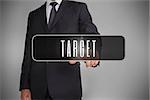 Businessman selecting label with target written on it on grey background