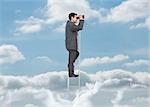 Businessman on ladder over the clouds looking at the horizon with binoculars