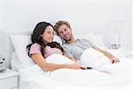 Couple in bed watching TV together