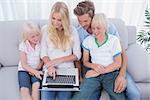 Cheerful family using laptop in the living room