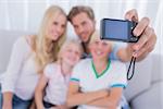 Father taking family picture in the living room