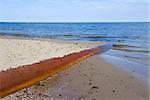 old rusted iron pipe dripping  in clear blue  sea