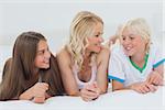 Cheerful family lying together on bed