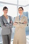 Confident businesswomen smiling at camera with arms crossed