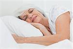 Peaceful woman sleeping in bed at home