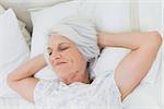 Peaceful mature woman relaxing in bed
