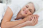 Mature woman sleeping in bed