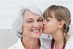 Portrait of a cute little girl kissing her grandmother