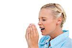 Sick blonde woman sneezing with hands in front of her face on white background