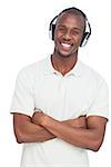 Smiling man listening to music with arms crossed on a white background