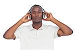 Concentrated man listening to music on a white background