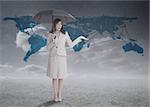 Businesswoman in front of blue map holding her umbrella and smiling
