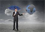 Businessman with blue umbrella showing earth