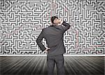 Puzzled businessman looking at a maze drew on a wall
